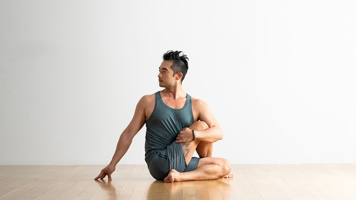 A person demonstrates Ardha Matsyendrasana (Half Lord of the Fishes Pose/Seated Twist Pose) in yoga