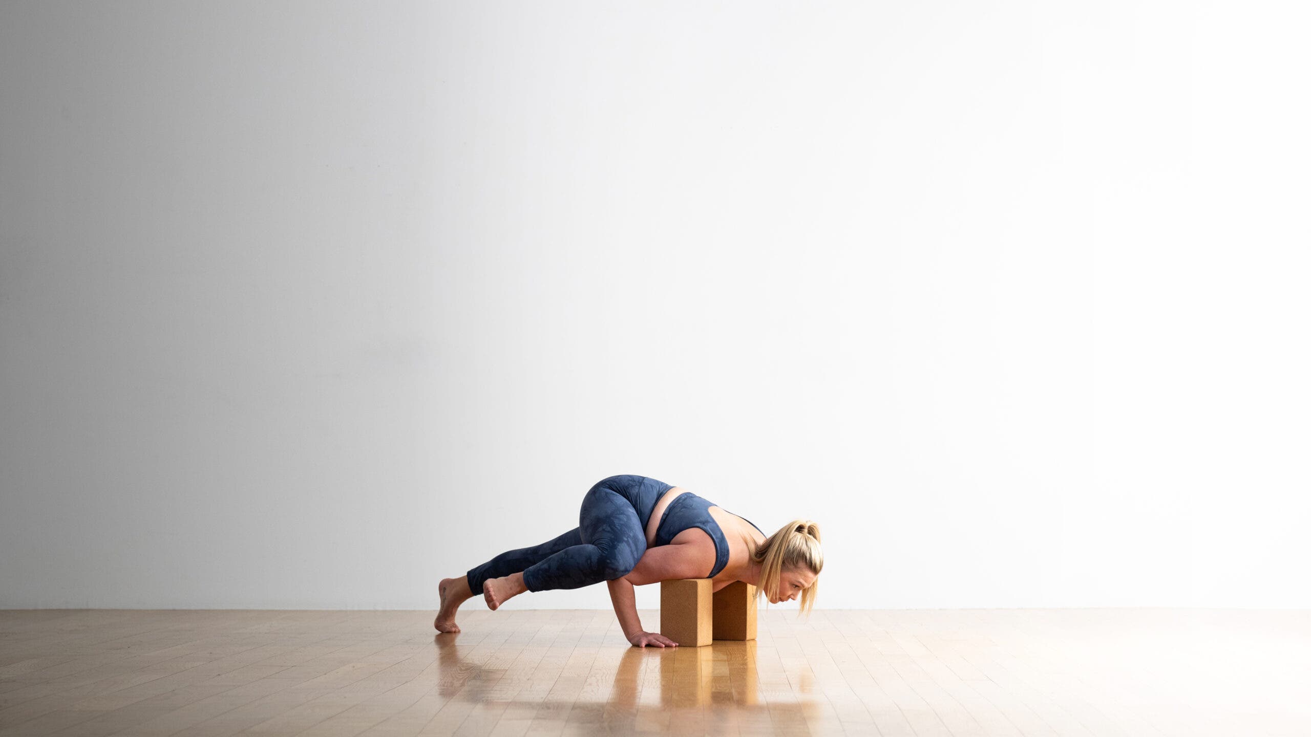 Sarra Raney practices a variation of Koundinyasana (Pose for Sage Koundinya) using cork blocks under her shoulders.