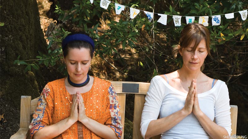 Two women meditating in garden