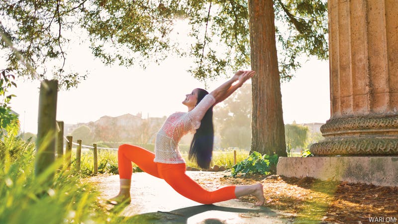 woman doing yoga outside kneeling crescent backbend pose