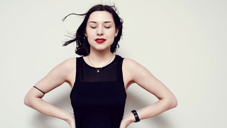 Woman stands with her eyes closed