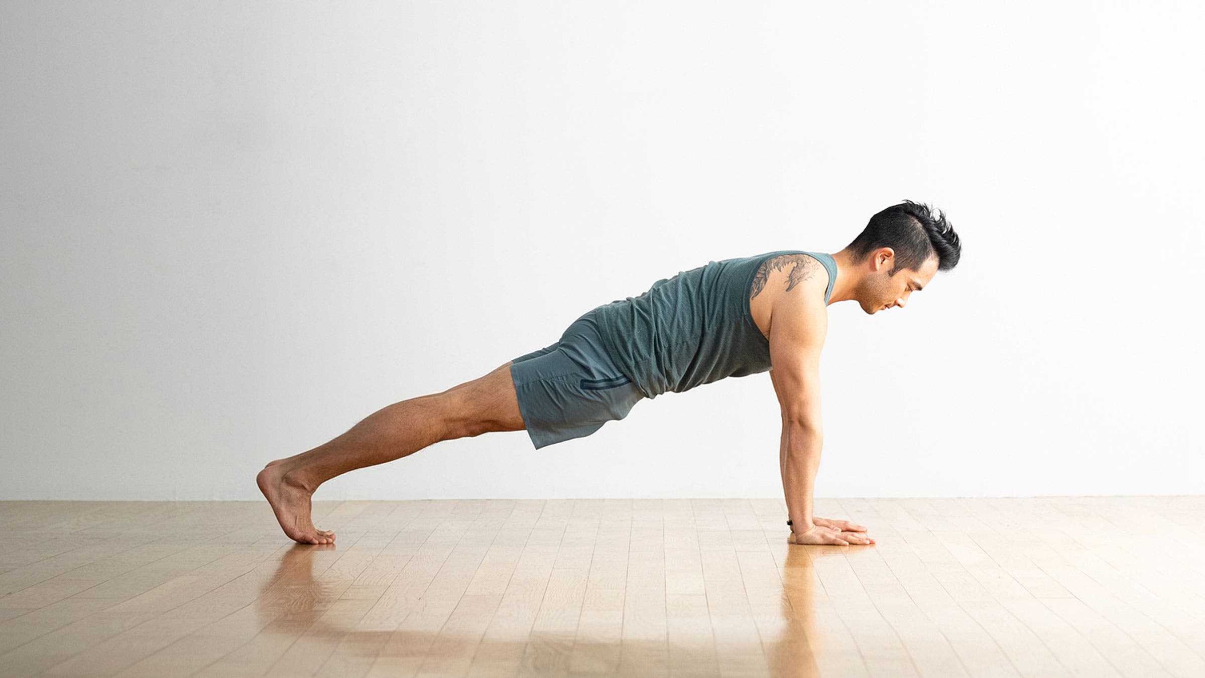 Man holding the top of a pushup, also known as Plank Pose in yoga