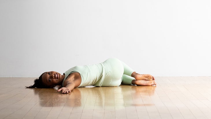 A person demonstrates a reclining supported twist in yoga