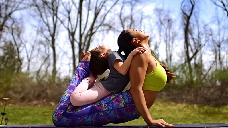 Laura Kasperzak of Two Fit Moms doing yoga with her daughter.