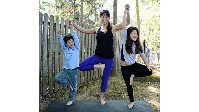 Masumi doing Tree Pose with her kids.