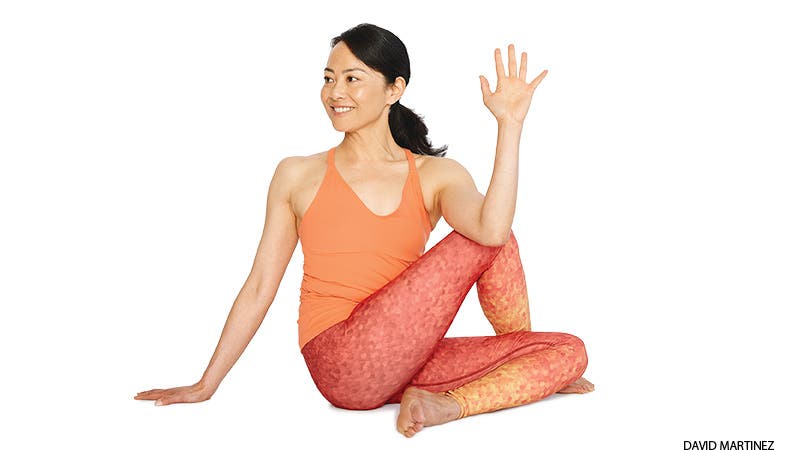 A woman demonstrates Ardha Matsyendrasana (Half Lord of the Fishes Pose) in yoga to ease constipation