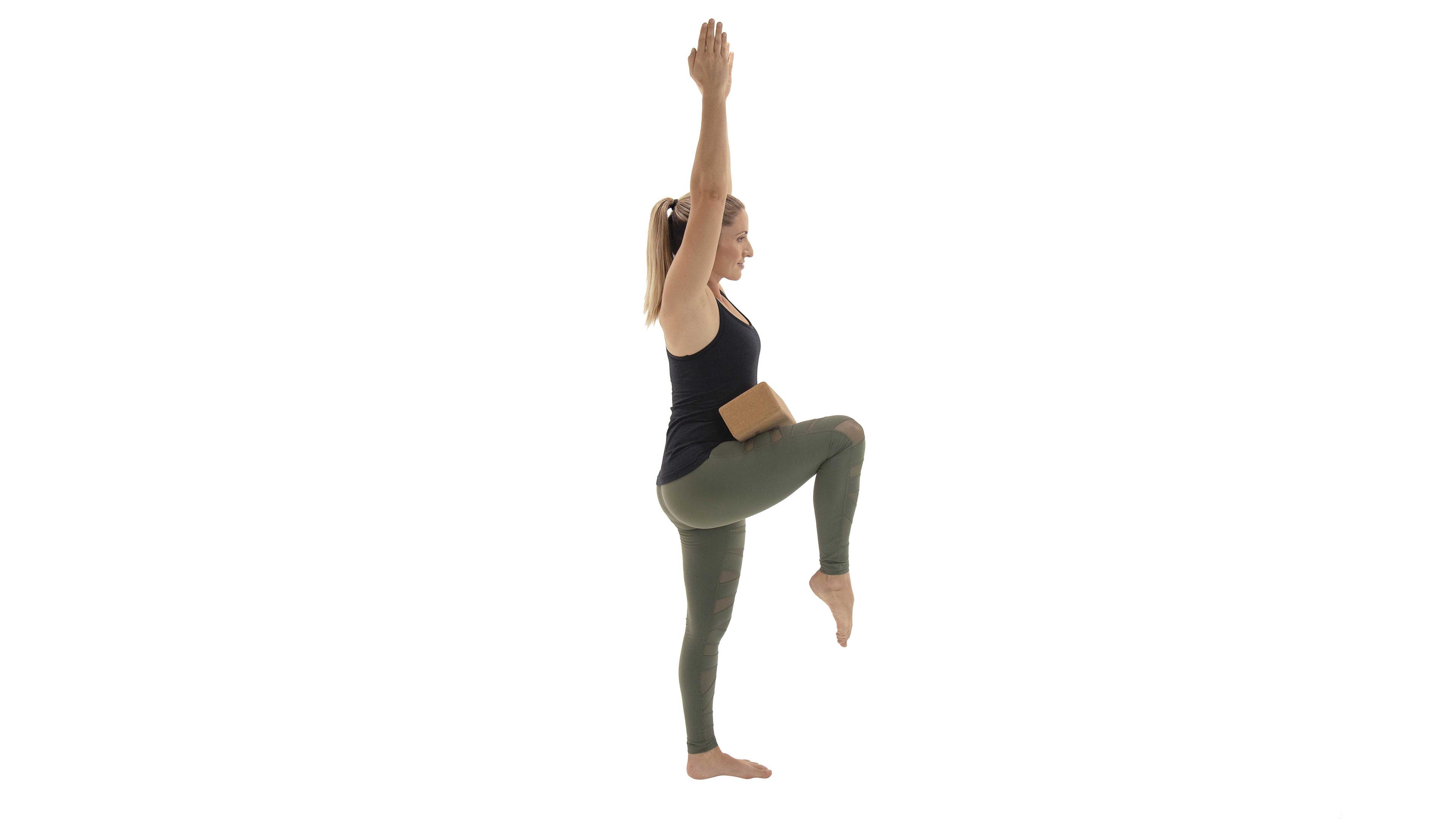 woman practicing standing knee to chest variation