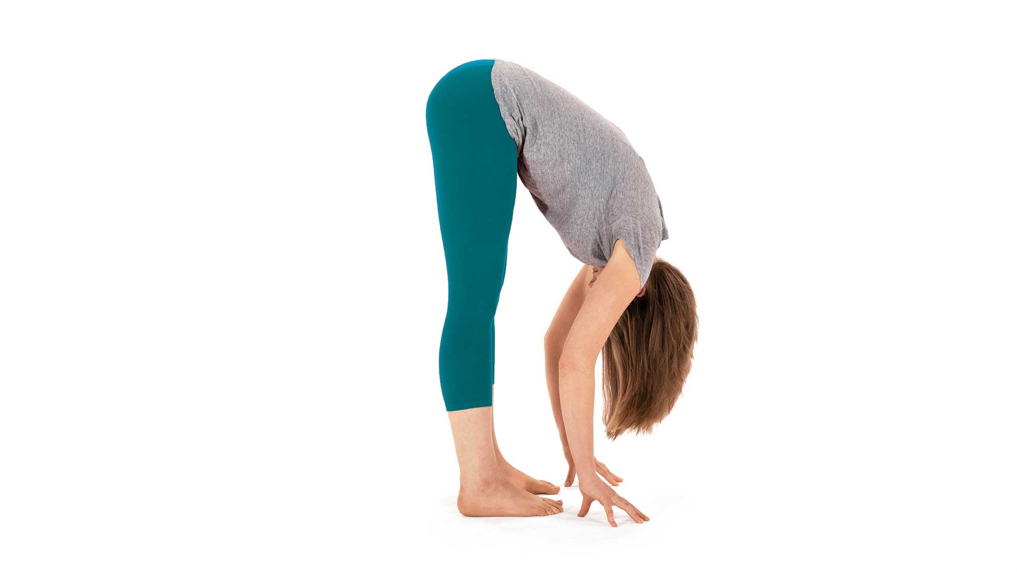 A woman demonstrates Uttanasana (Standing Forward Bend)