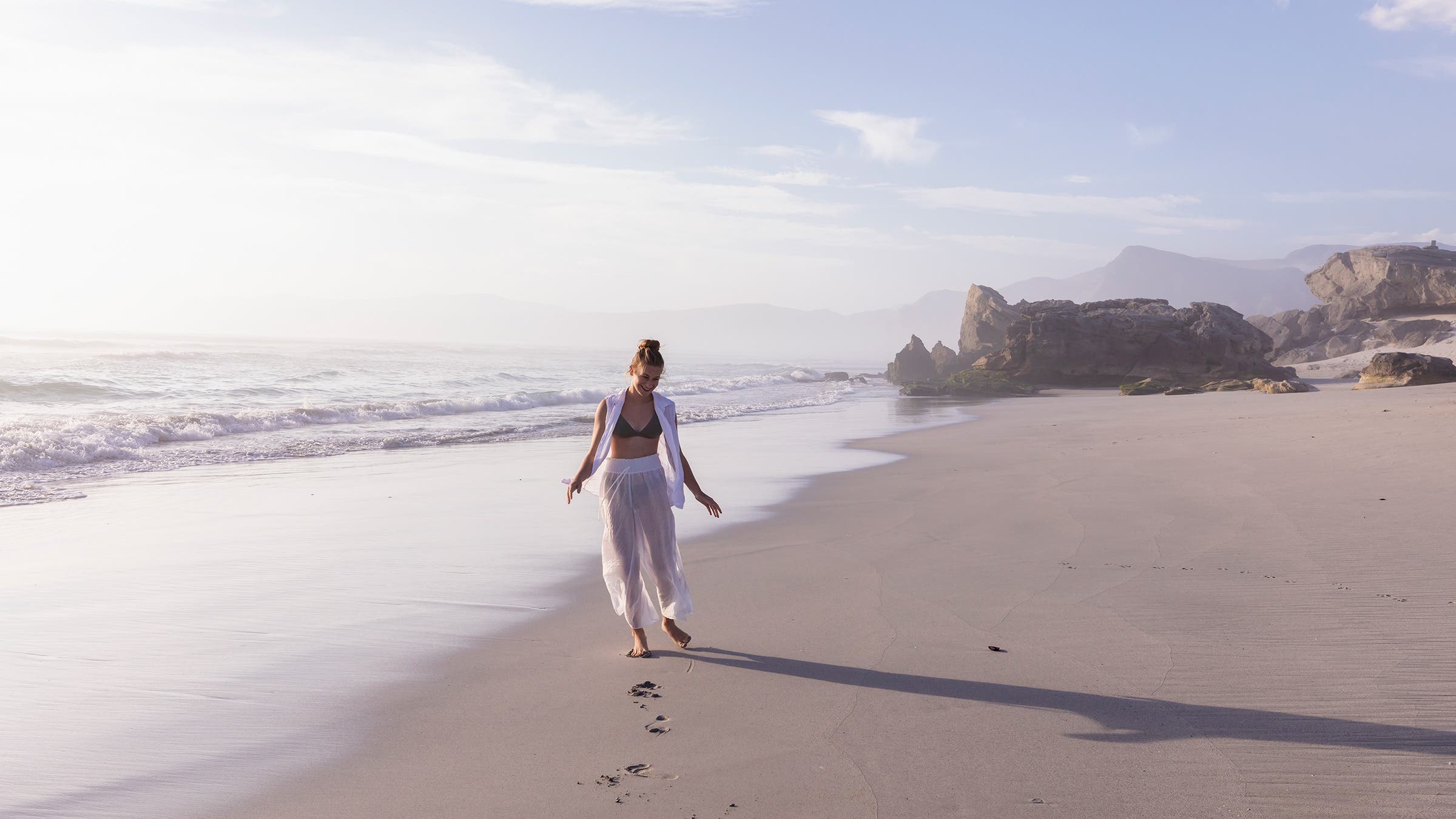 A person walks along the beach in Walker Bay Nature Reserve in South Africa