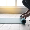 woman unrolling a yoga mat