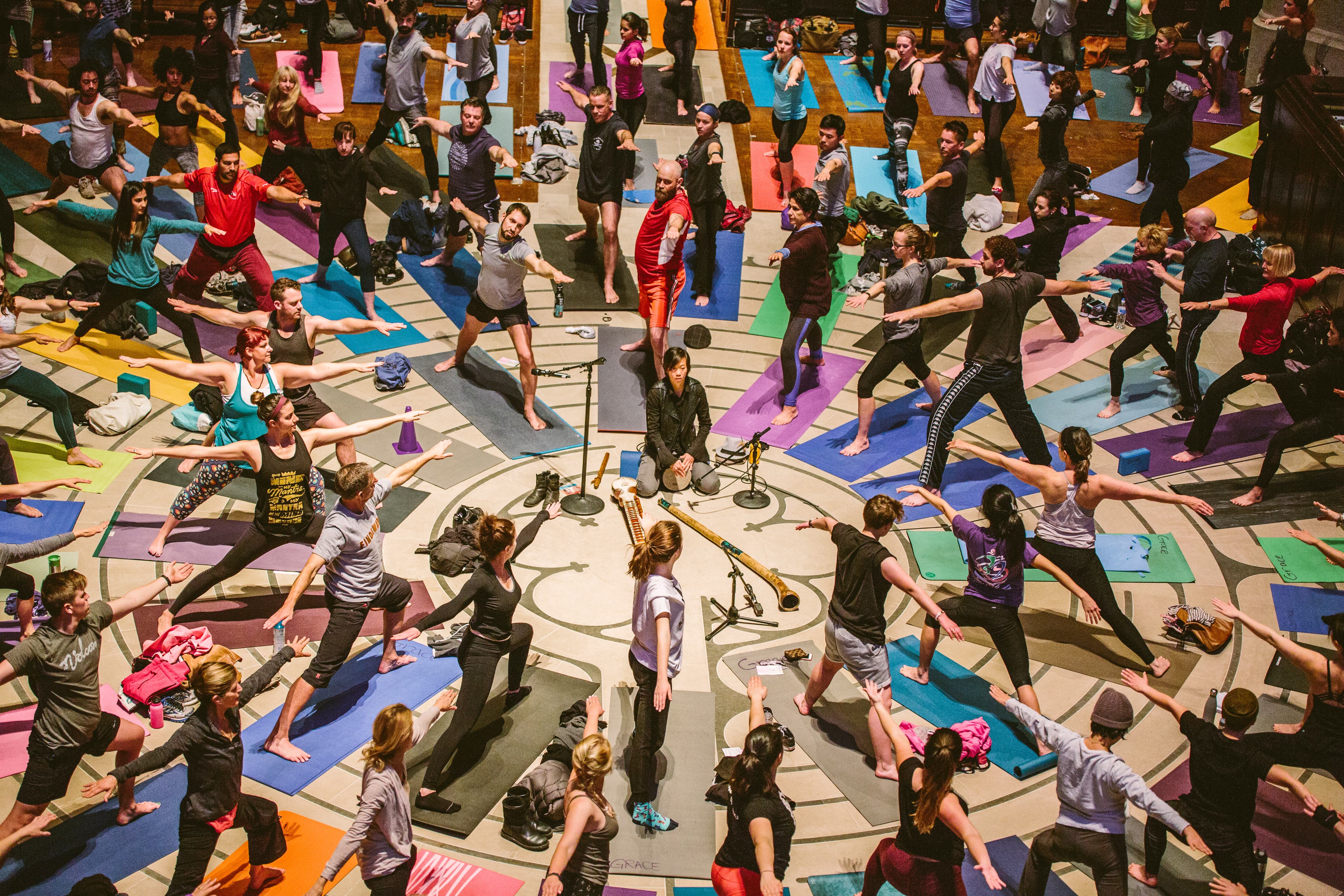 amberfield@gracecathedral_51 A large group of yogis arranged on the Cathedral labyrinth in Warrior Pose II