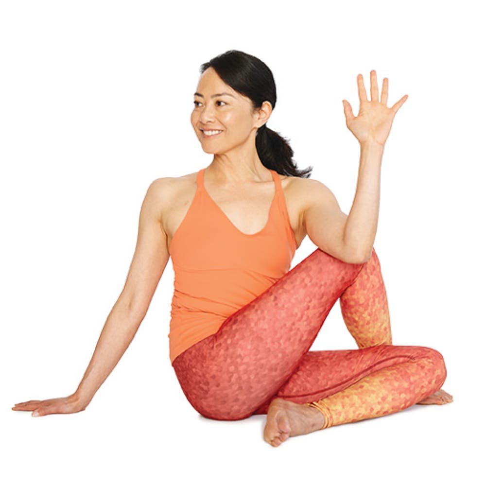 Woman performing half lord of the fishes pose