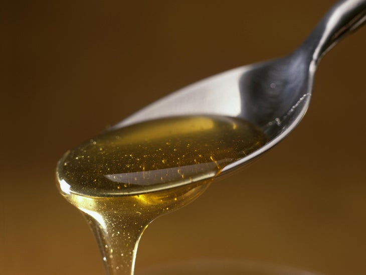 Honey running from a teaspoon honey, spoon