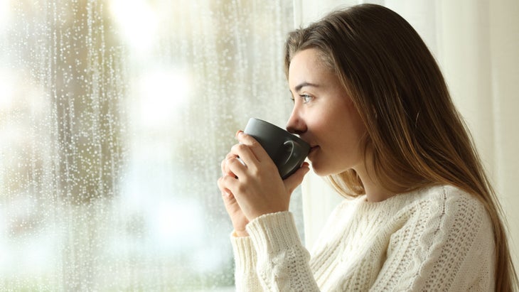 teen-drinking-coffee-looking-through-a-window-a-rainy-day-picture-id905969020 None