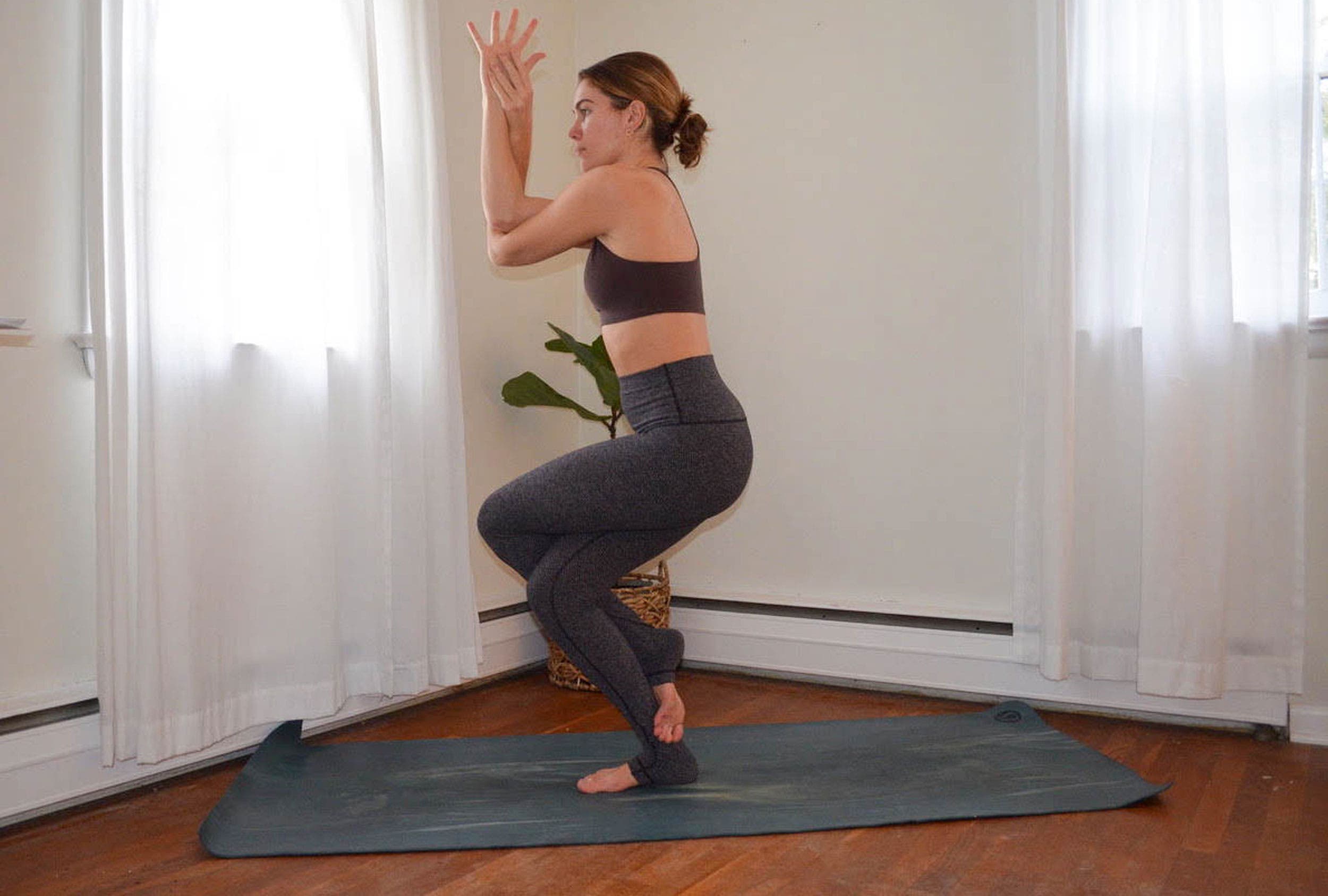 A woman demonstrates Garudasana (Eagle Pose) in yoga