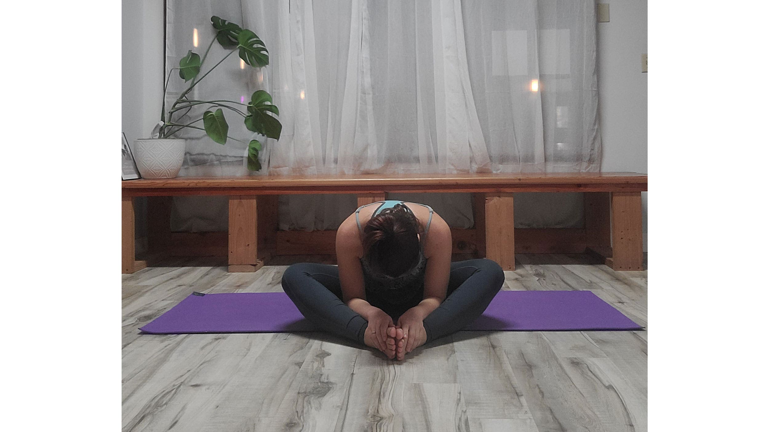 A person performs Baddha Konasana (Bound Angle Pose)  