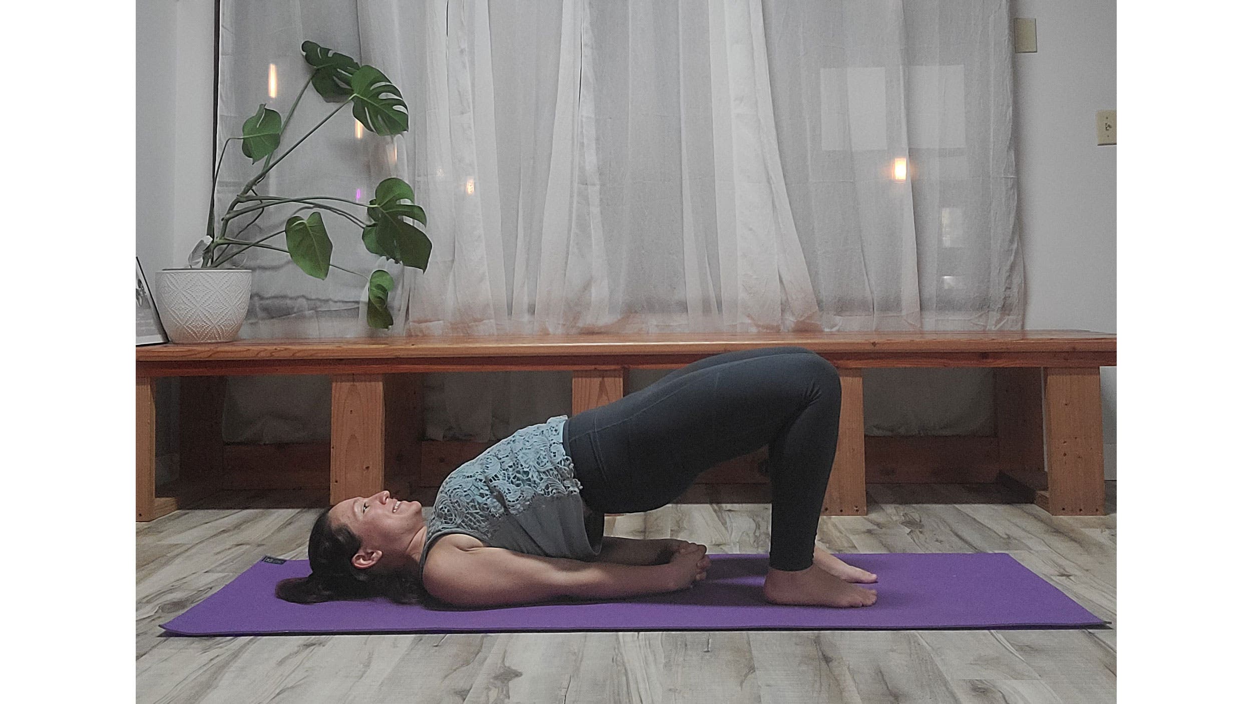 A person performs Setu Bandha Sarvangasana (Bridge Pose)