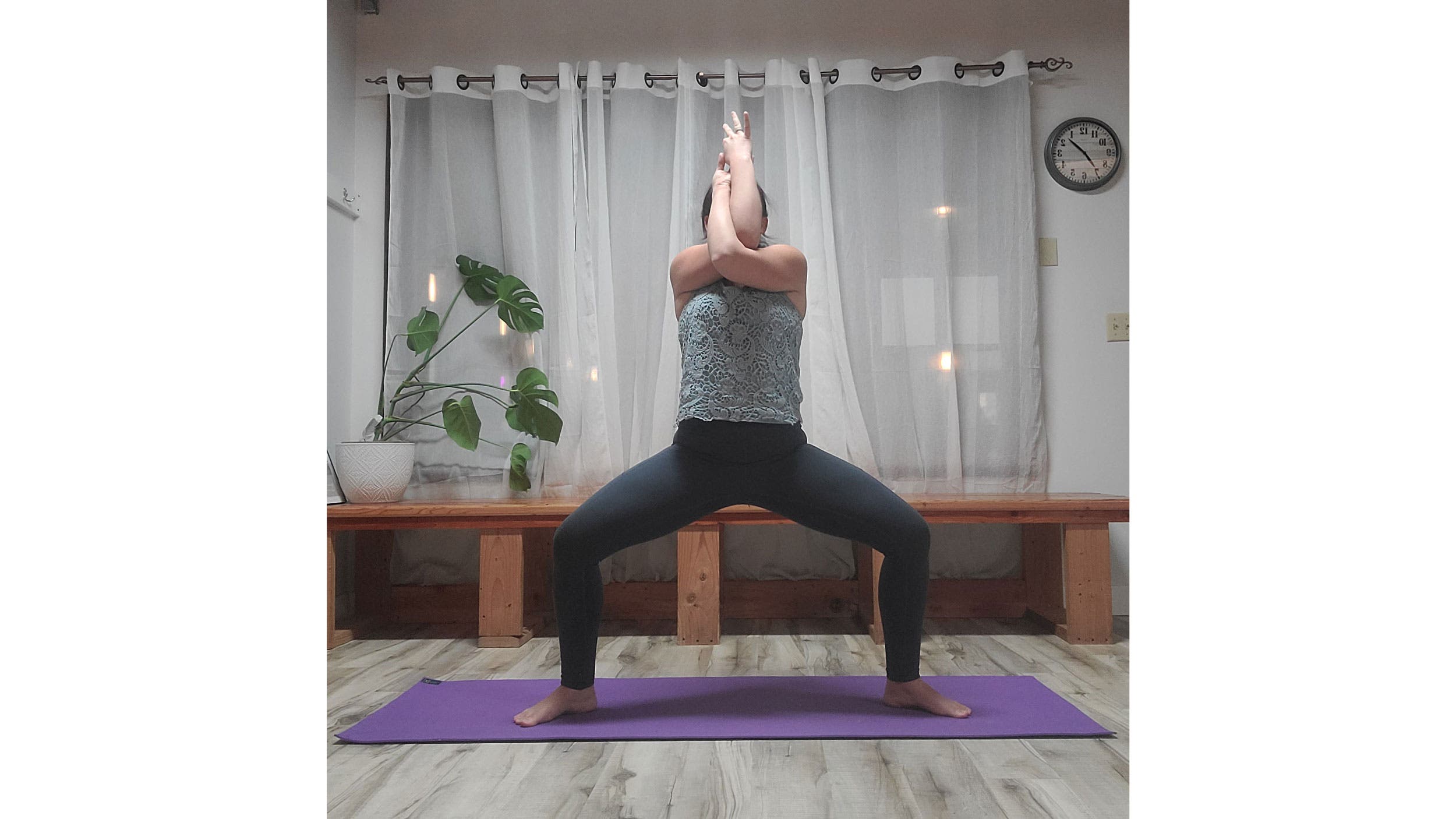 A person performs Utkata Konasana, variation (Goddess Pose)