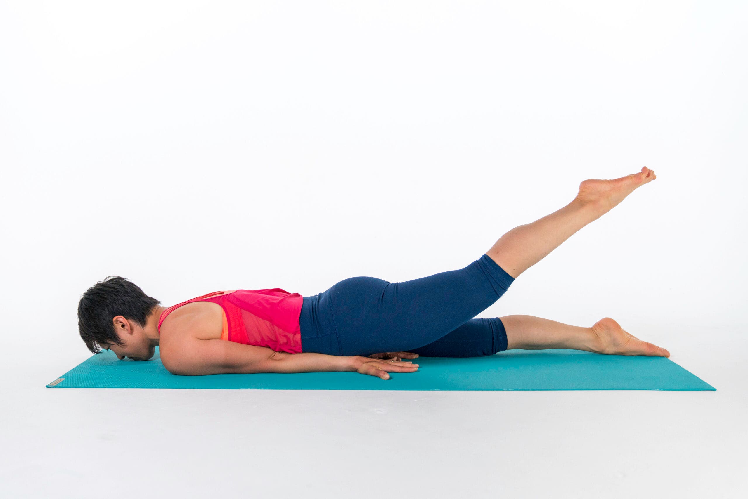 A person demonstrates a variation of Locust Pose, Half Locust Pose with one leg lifted, head down