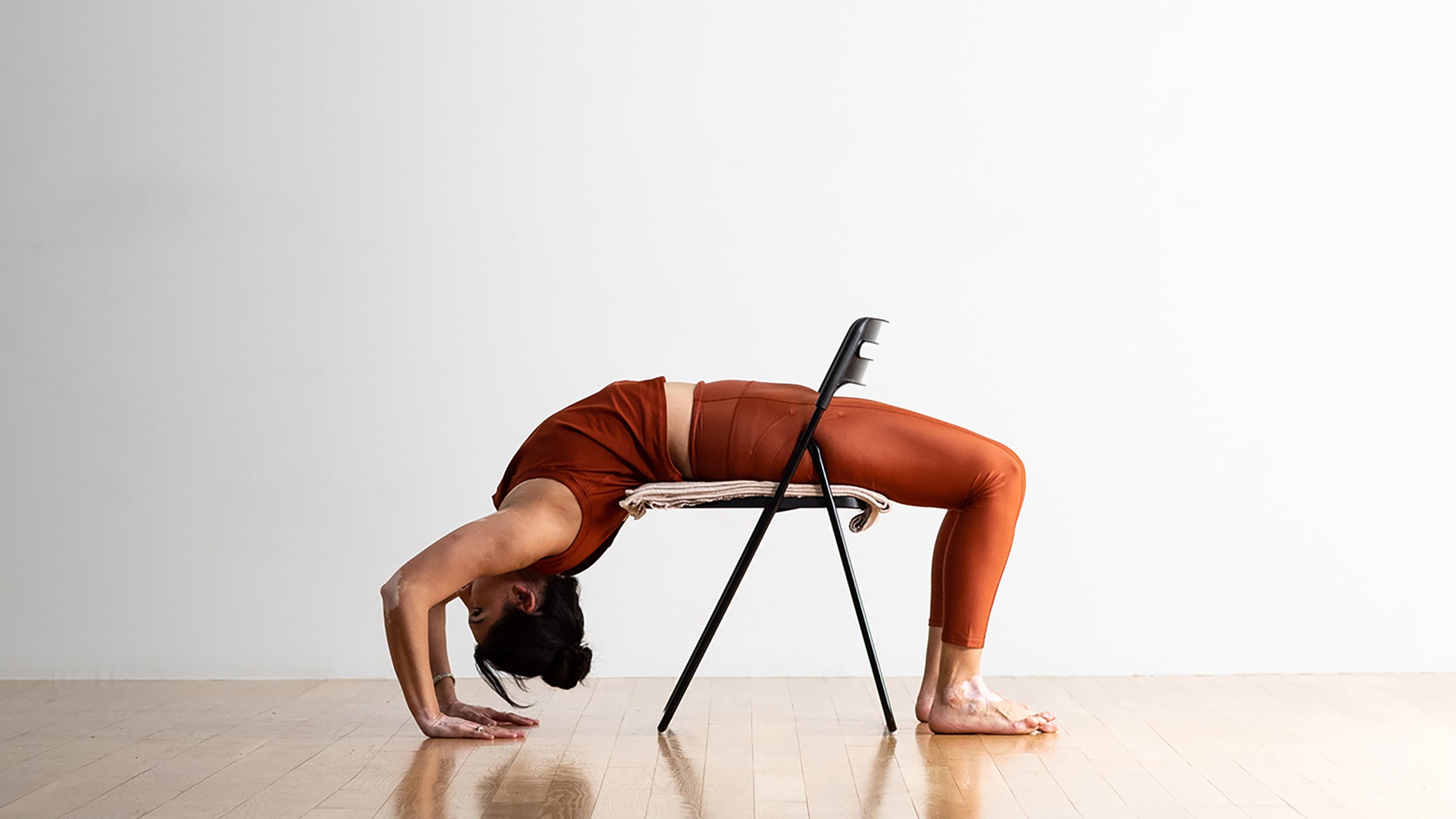 Person in a Wheel Pose variation on a chair