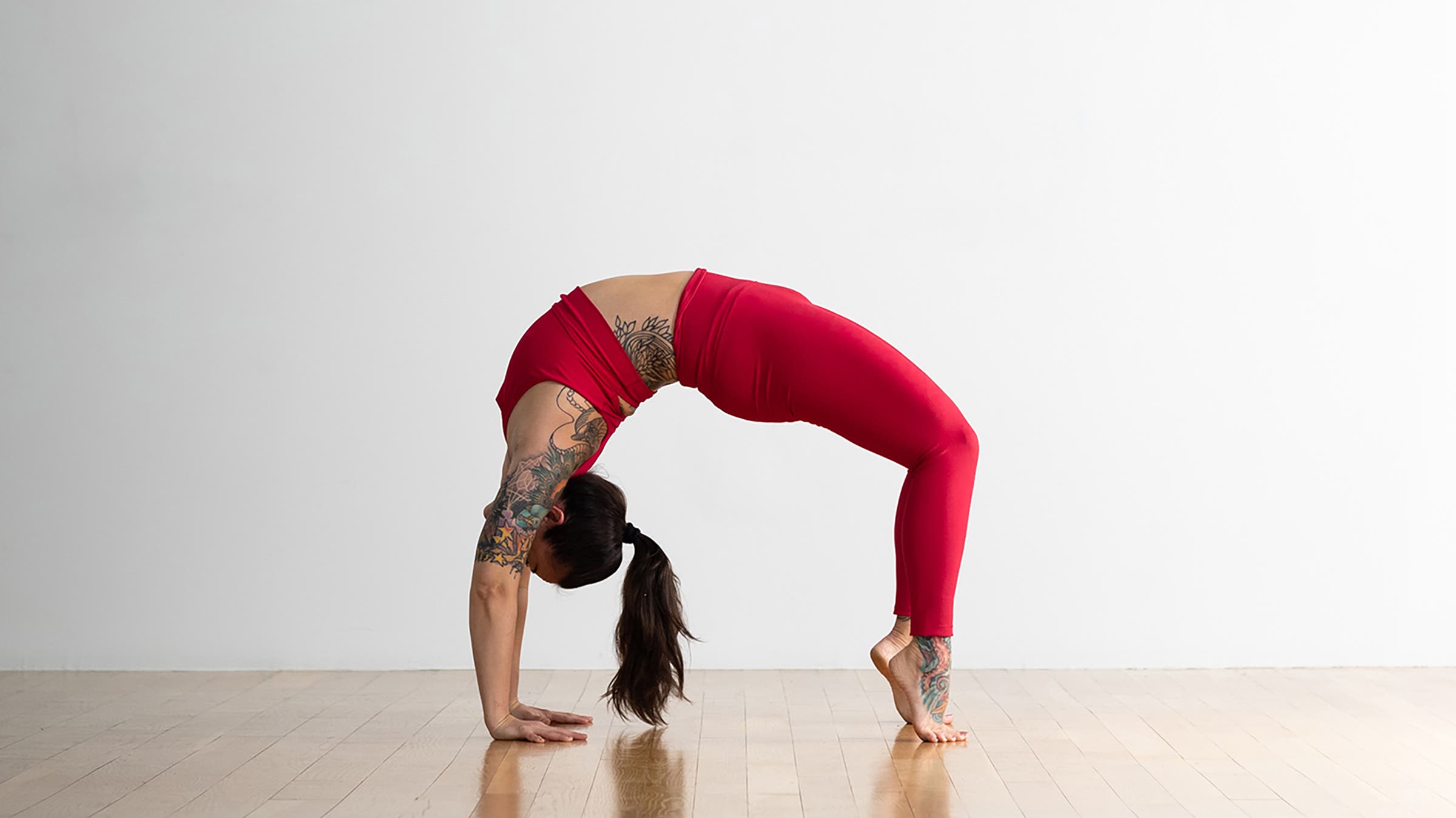 Person demonstrating Wheel Pose variation on the toes