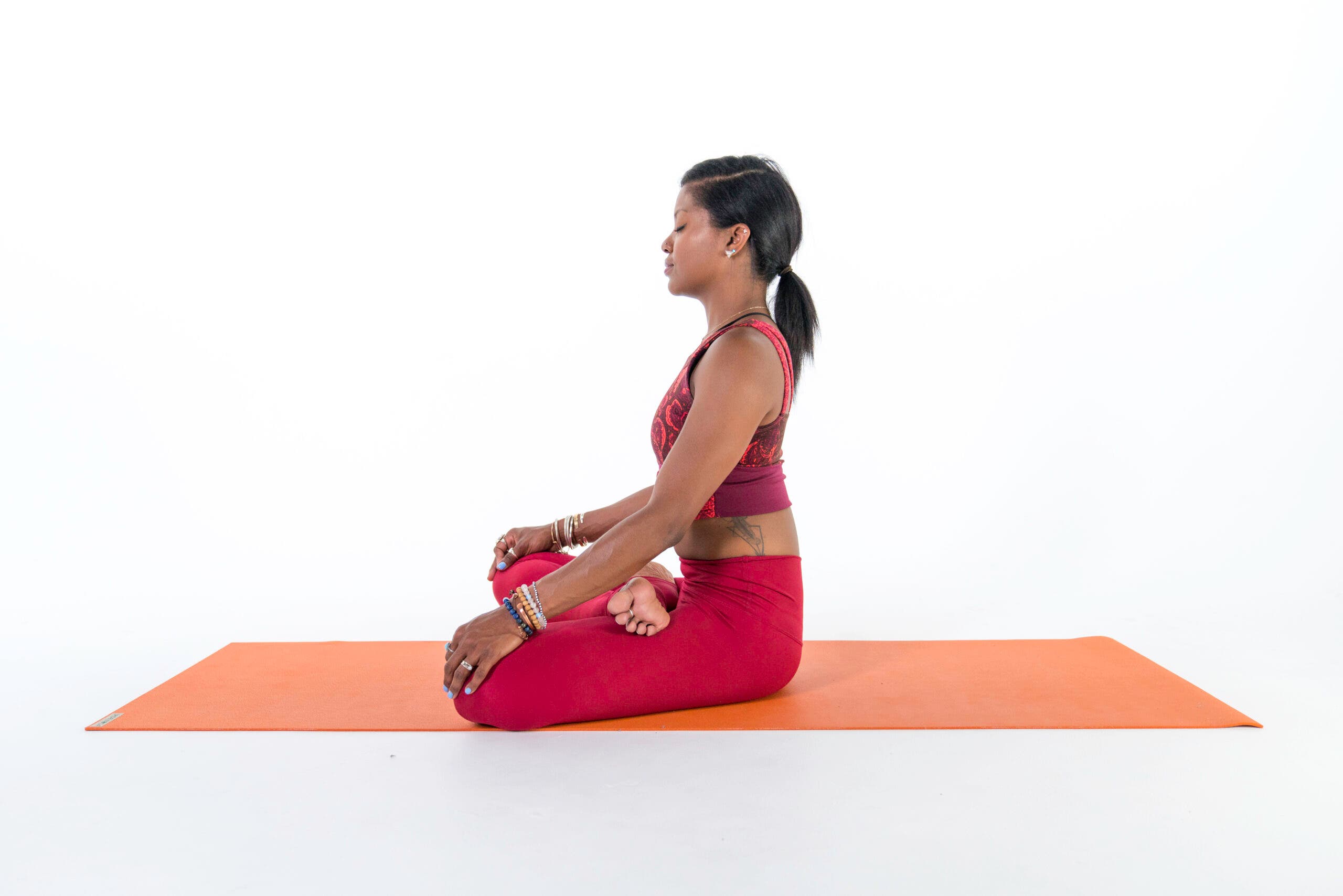 A woman sits in Lotus Pose (Padmasana)