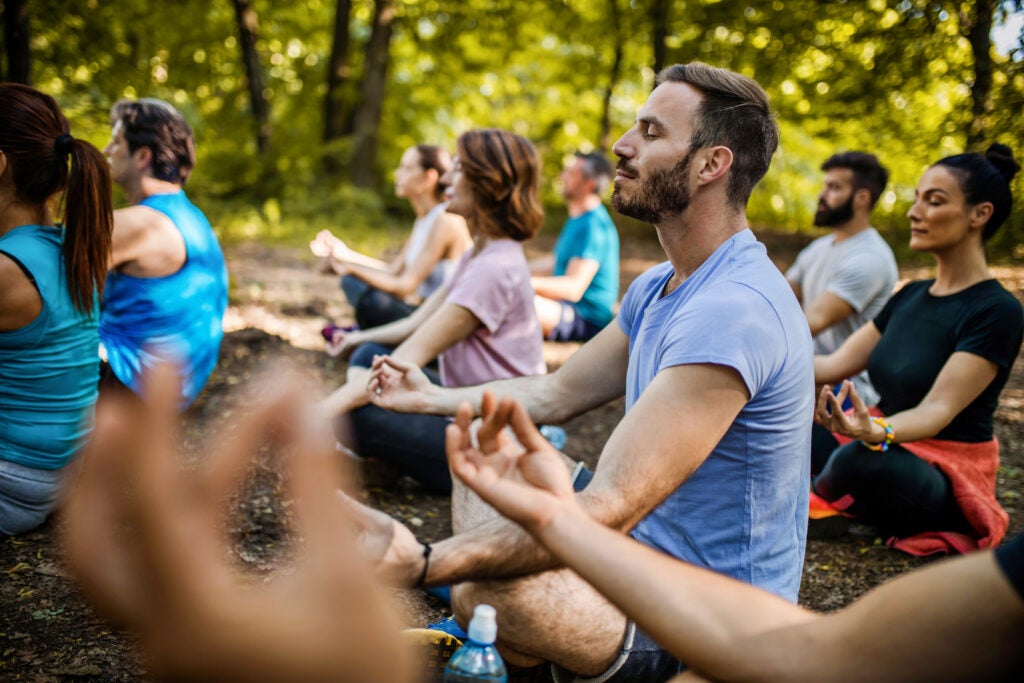 Group of people doing yoga outdoors.