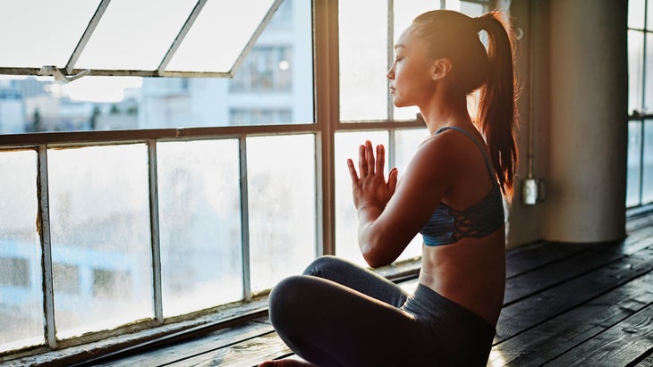 Young woman meditates at her window