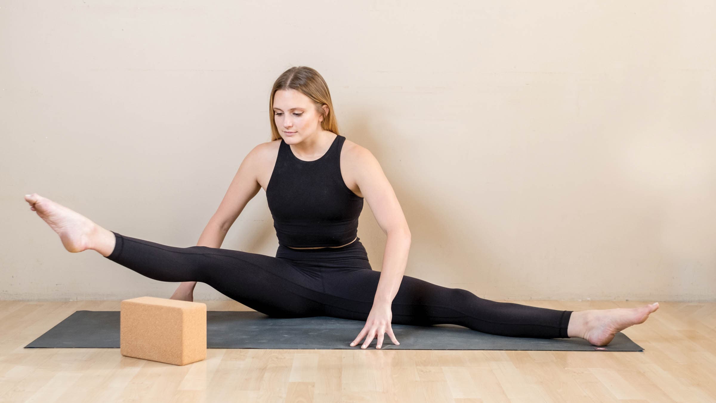 Woman performing a wide-angle seated forward bend variation