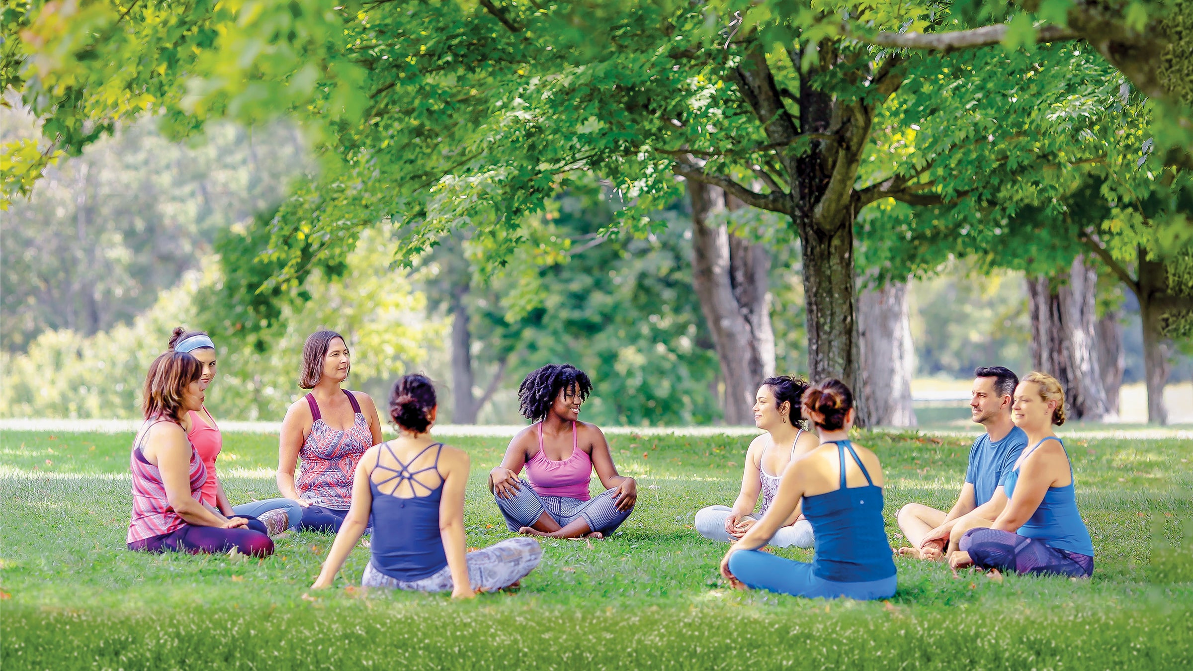 Yoga group sitting in a circle at a park