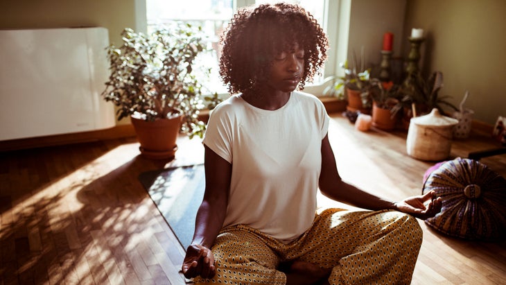 Woman sits and meditates on the ground