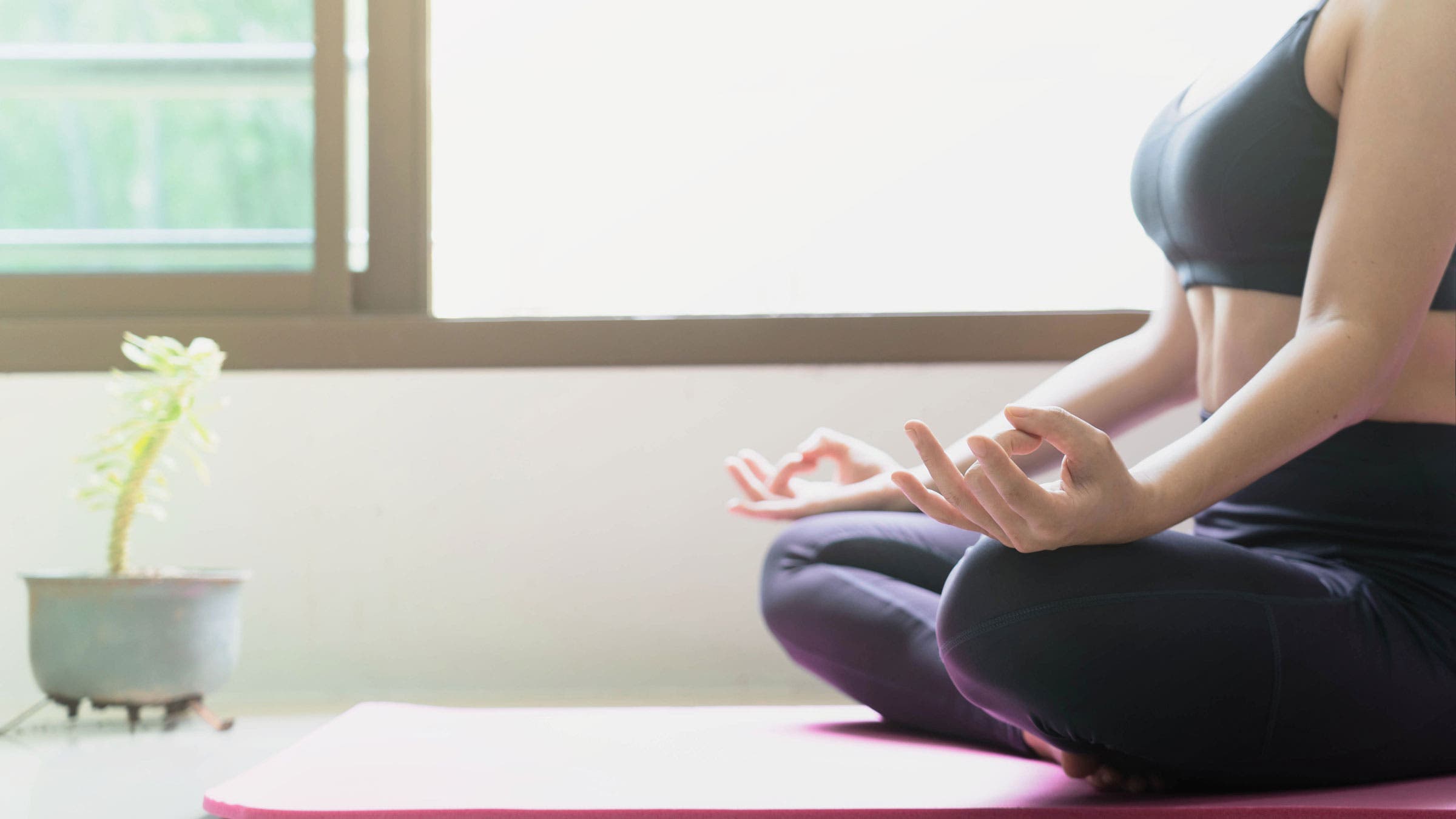Woman sits on the floor while meditating