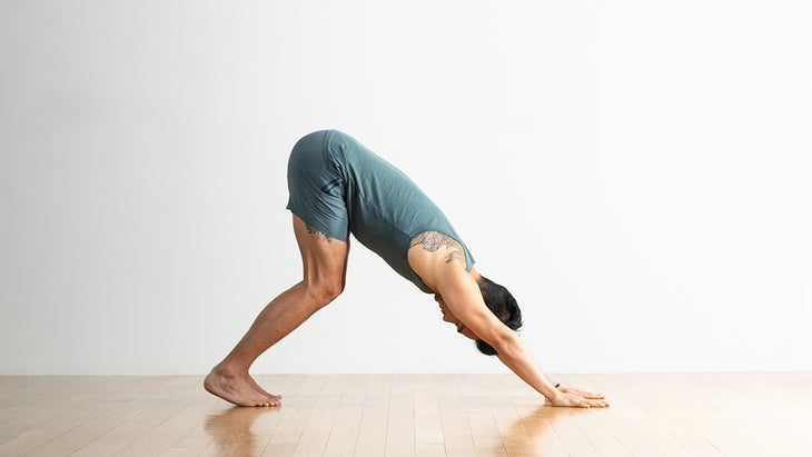 Man performing a Downward-Facing Dog modification with bent knees