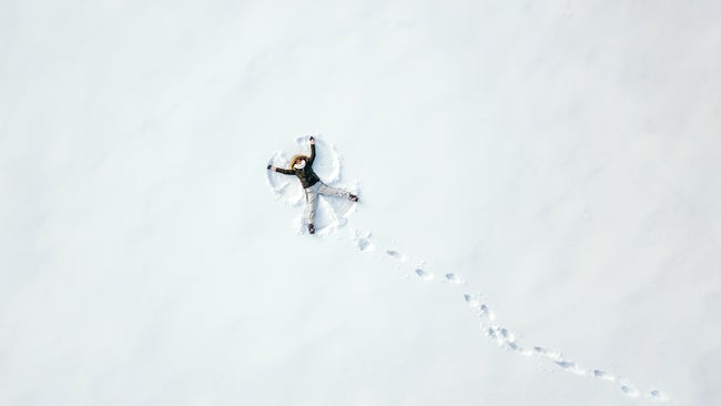 Above shot of someone making a snow angel in a field