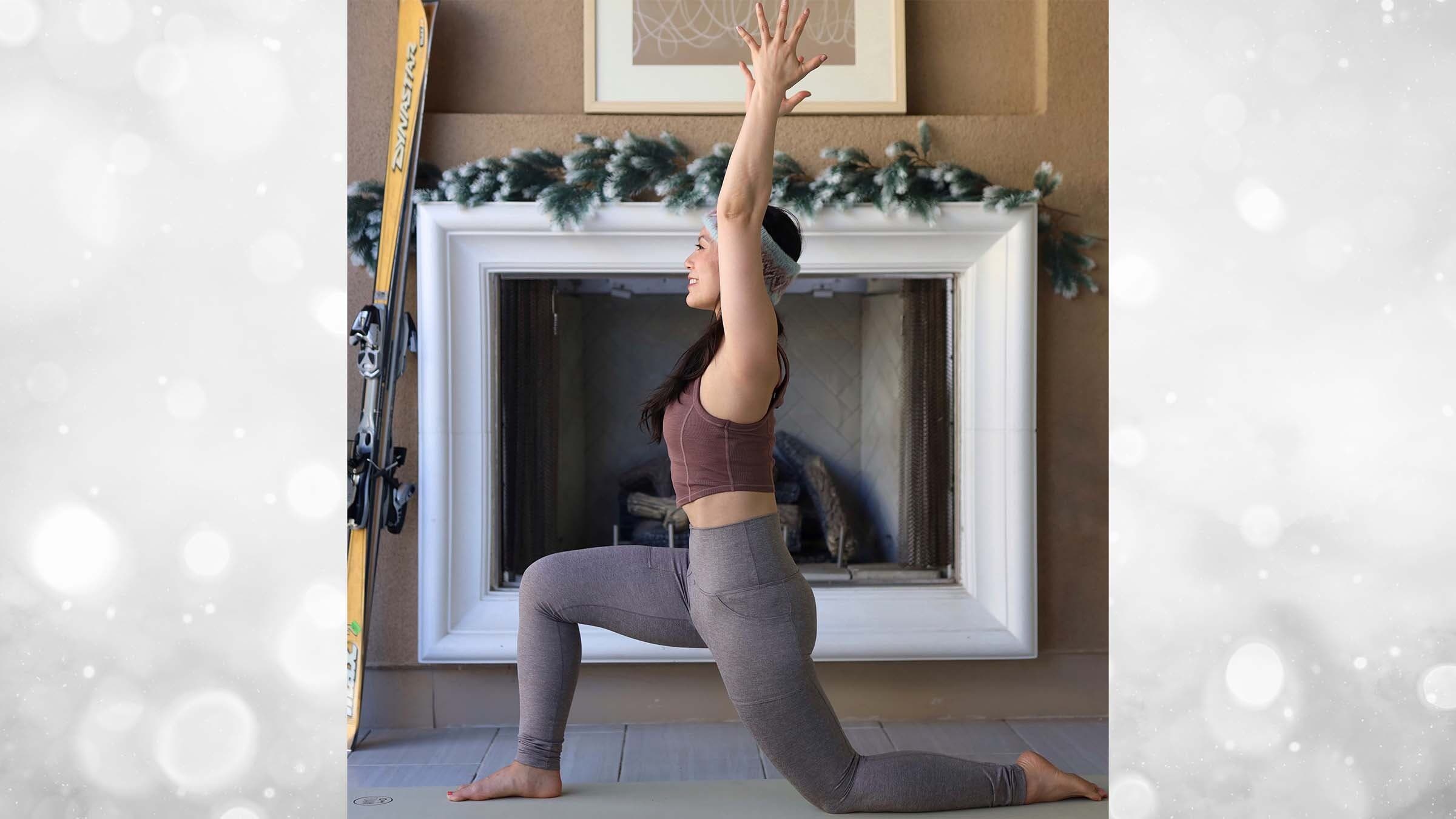 Ingrid Yang in crescent lunge in front of a fireplace
