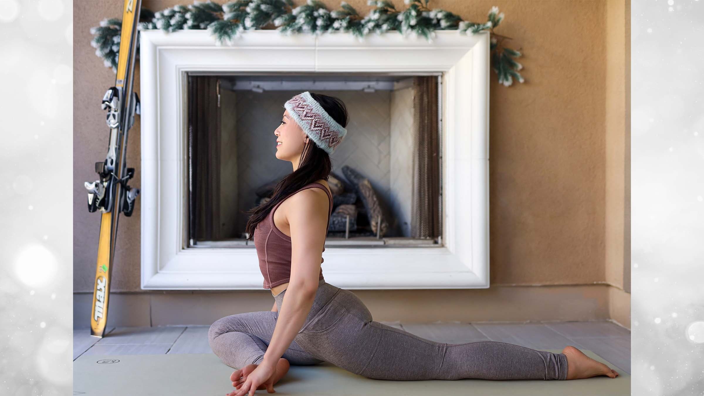 Ingrid Yang in pigeon pose in front of fireplace