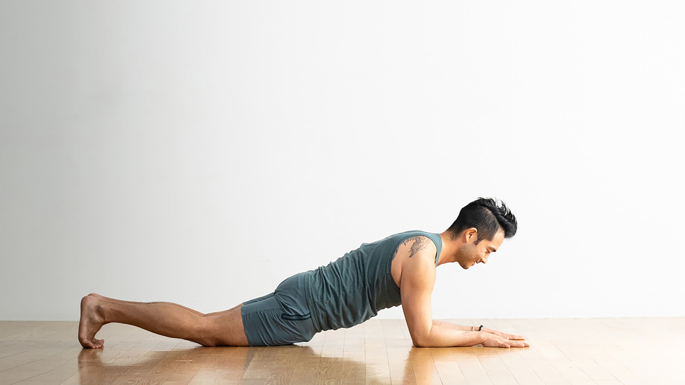 A person demonstrates a variation of Forearm Plank Pose with their knees on the ground