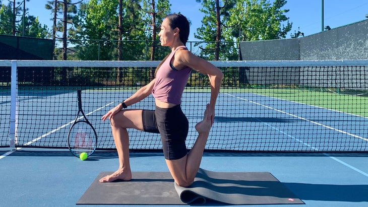 A person demonstrates Crescent Lunge in yoga on a tennis court