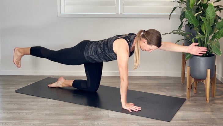 A person practices bird dog in yoga 