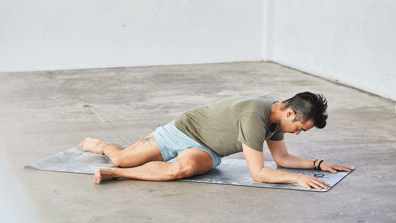 A moving image shows a person demonstrating lazy Pigeon Pose
