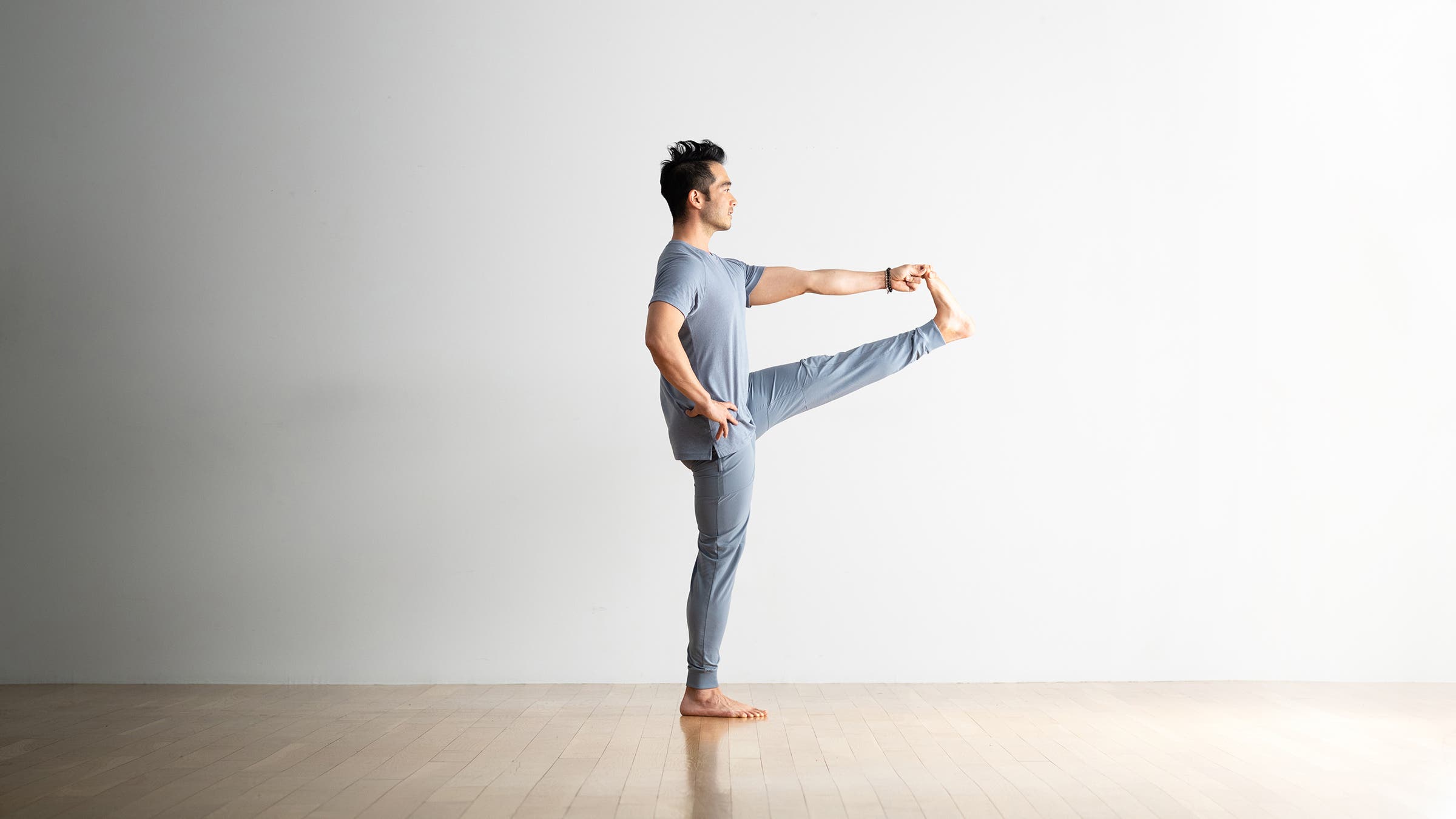 Hiro Landazuri practices Utthita Hasta Padangusthasana (Extended Hand to Big Toe Pose), a yoga pose for leg strength