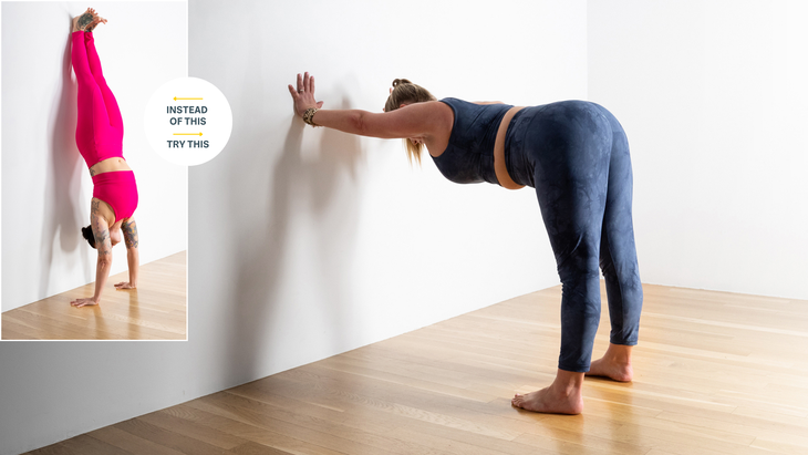 Soozie Kintsler wearing hot pink yoga tights in Handstand with her feet against a white wall; In blue yoga tights Sarra Raney in Half foward bend reaching toward the white wall with her hands on the wall.