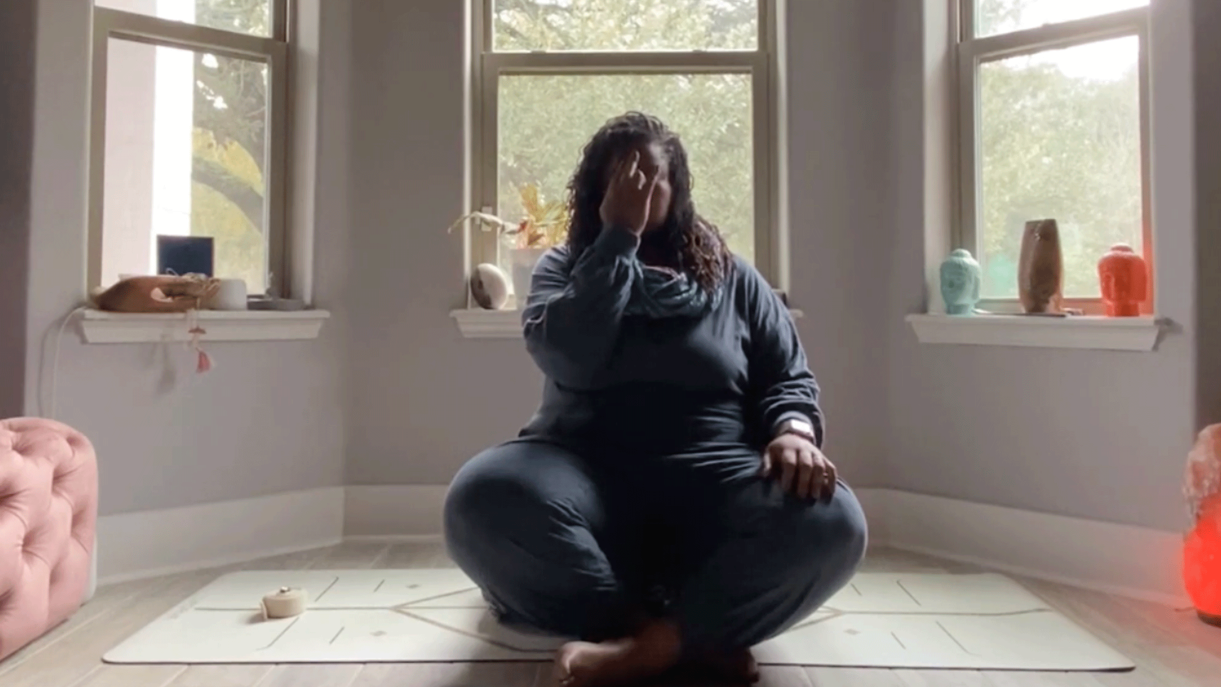 Woman doing breathwork in her bedroom