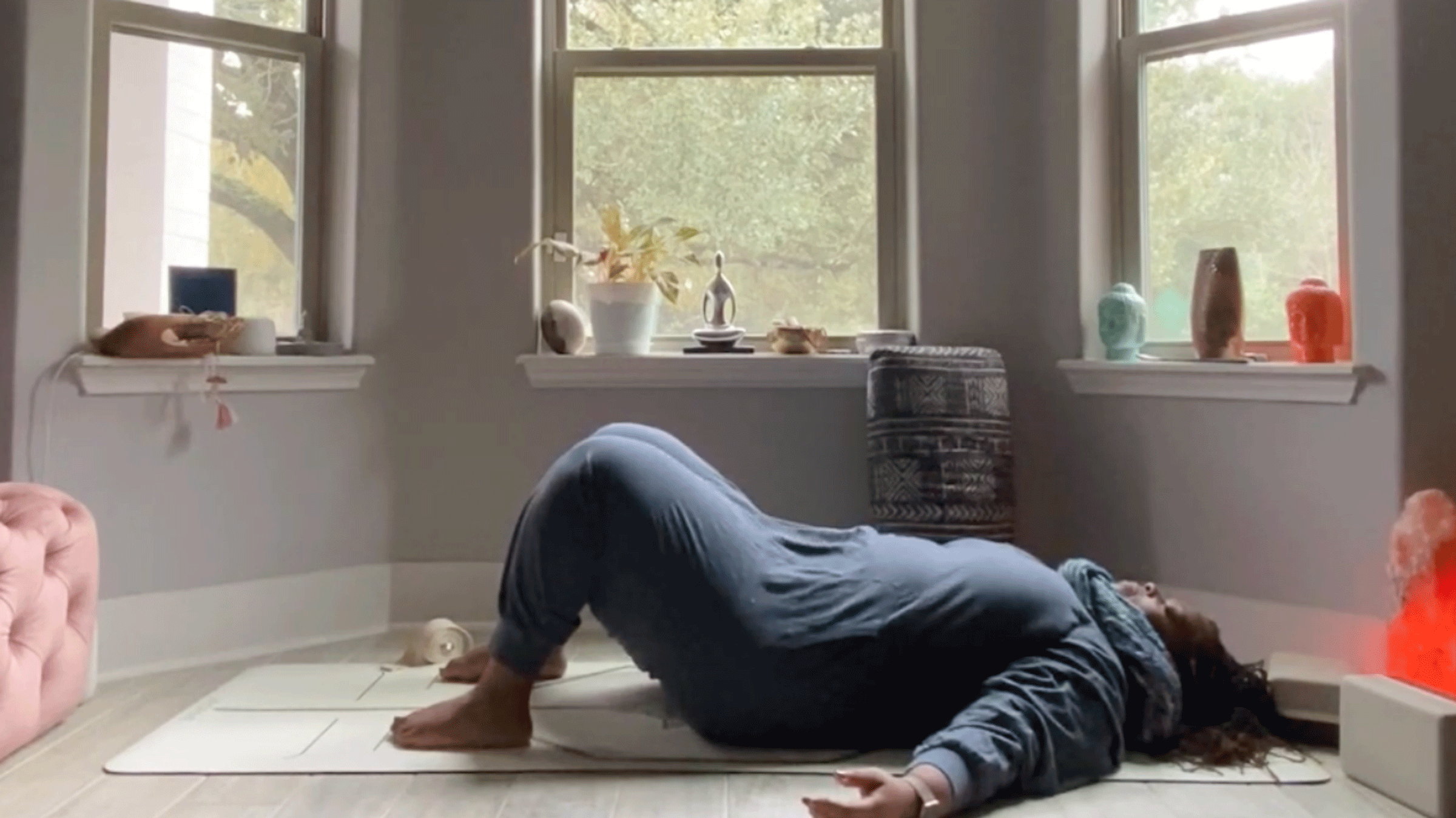 Woman stretching her low back in her bedroom