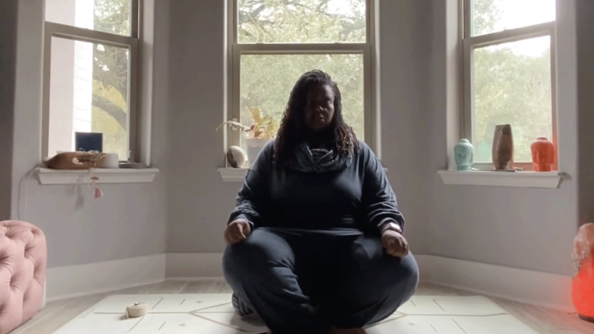 Woman sitting in her bedroom practicing Yin yoga