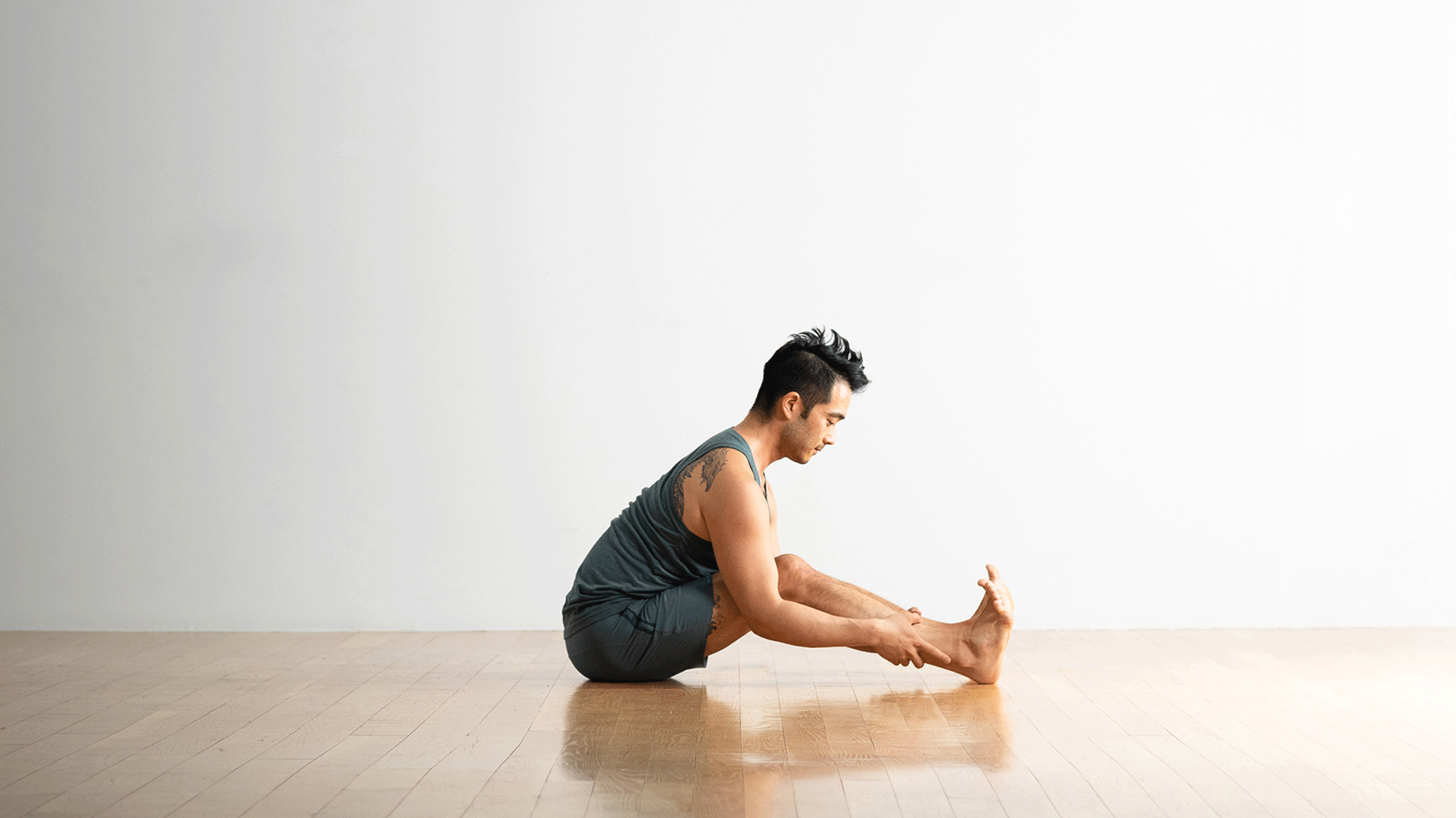 Man sitting and stretching tight hamstrings and low back
