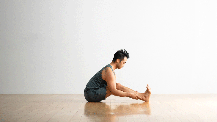 Yoga runner girl stretching back over legs doing seated Forward