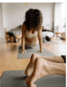 Students in yoga class with one mat perpendicular to the other mats