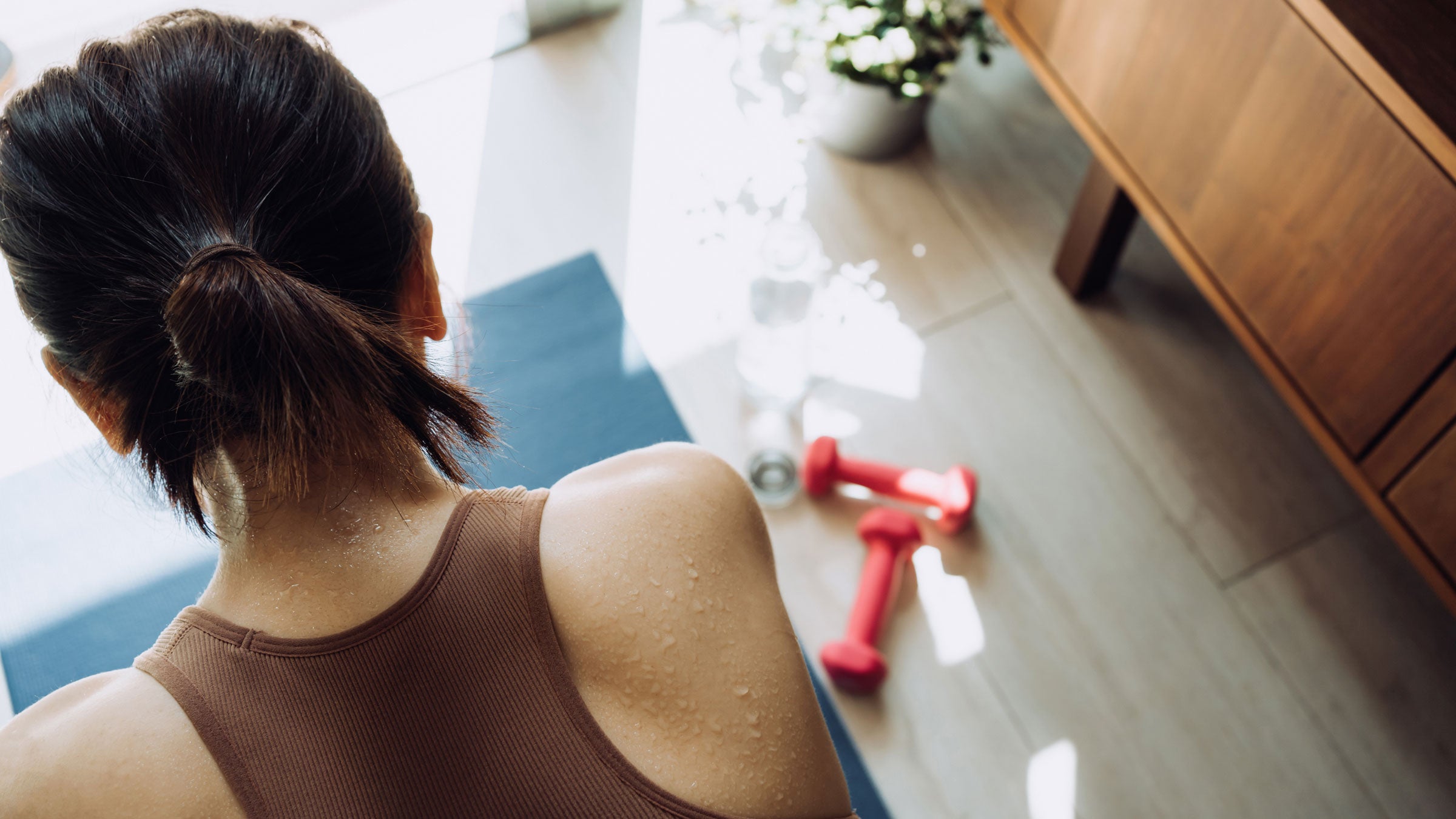 Sweaty woman does a yoga sculpt class