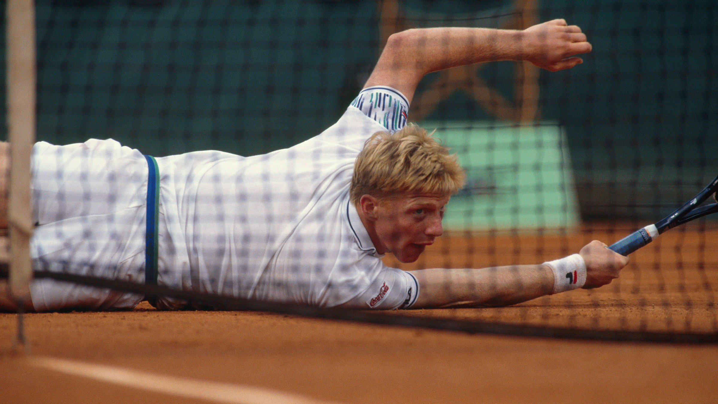 Boris Becker in the 1989 French Open on a clay court with his racket near the net